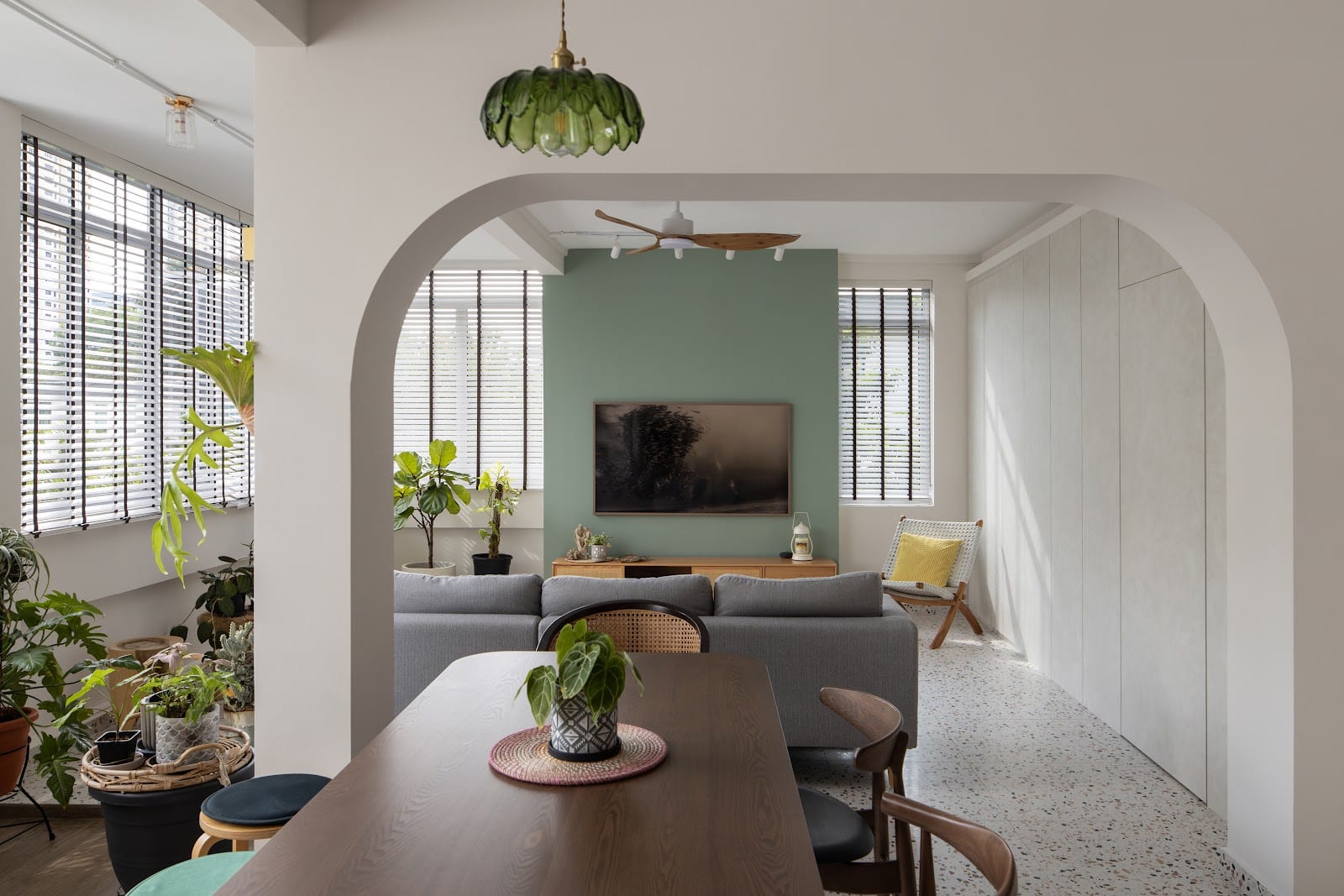 Earthy green tones and warm timber living room at Lim Liak residence